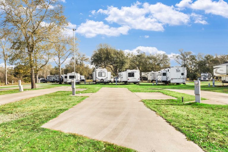 Vinton LA RV Park Vinton LA RV Park in Vinton Texas with paved RV parking, grassy sites, multiple RVs, trees, and blue sky with clouds.
