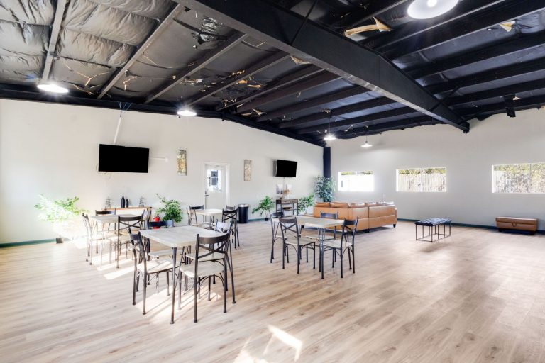 Vinton LA RV Park Vinton LA RV Park lounge in Vinton, Texas with light wood floors, sofas, TV, coffee table, plants, and large sunny windows.