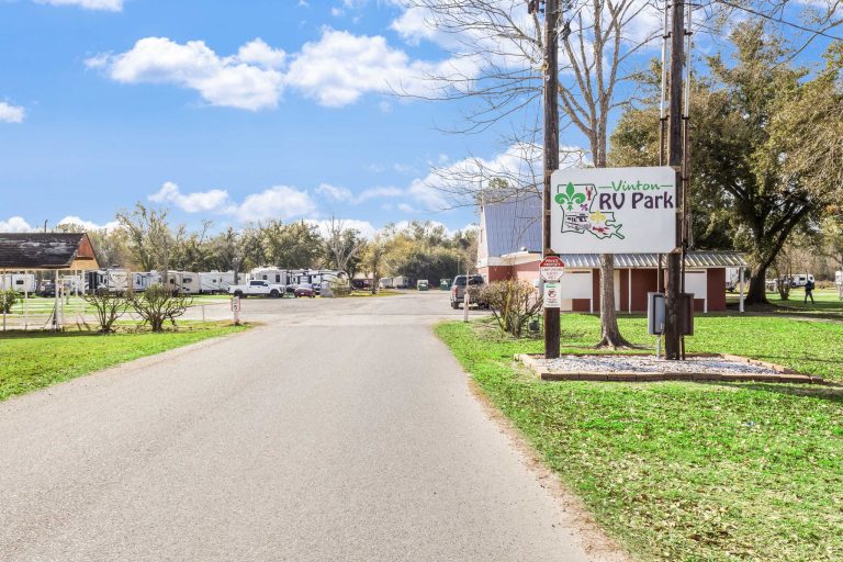 Vinton LA RV Park Vinton LA RV Park entrance in Vinton, Texas with sign by road, RVs, grassy areas, trees, and blue sky with clouds.