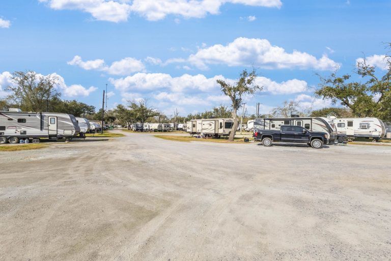 Vinton LA RV Park Vinton LA RV Park in Vinton, Texas with rows of RVs, gravel parking, black pickup truck, sparse trees, and blue sky.