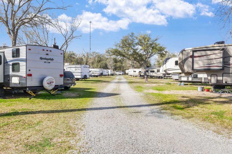 Vinton LA RV Park Vinton LA RV Park in Vinton, Texas features a gravel road, travel trailers, fifth-wheel campers, grassy areas, trees, and blue sky.